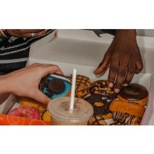 A literal squad of students straight up flexing with a lit box of donuts and some iced-out drinks they copped with that 20% big drip. No cap.