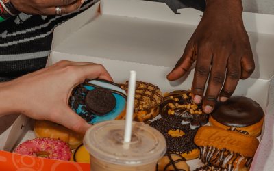 A literal squad of students straight up flexing with a lit box of donuts and some iced-out drinks they copped with that 20% big drip. No cap.